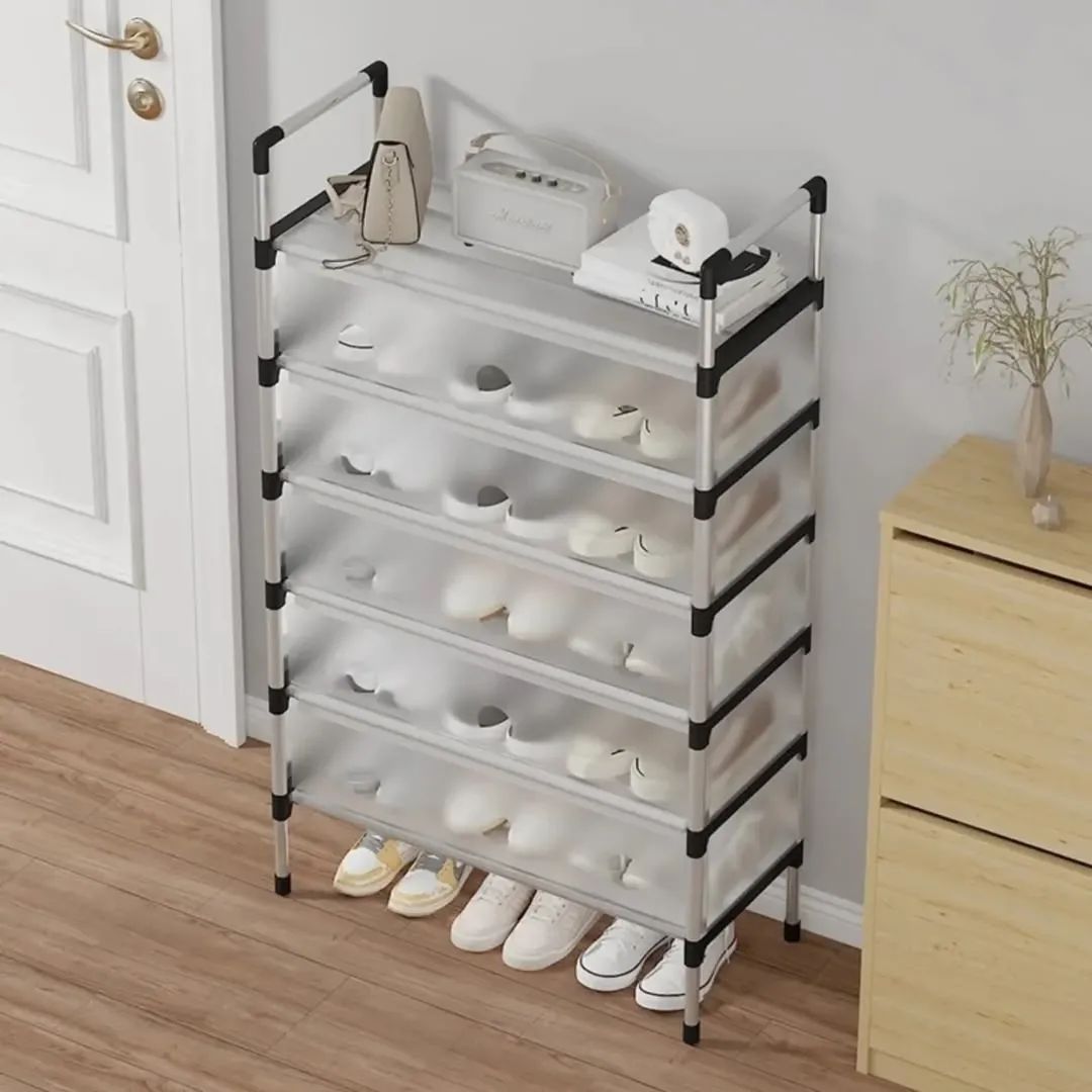 Clear shoe organizer with white shoes on a wooden floor next to a wooden cabinet.